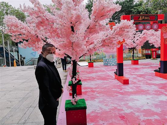 2020年1月26日，广州地王广场，一位游客被桃花吸引。